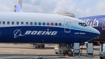 Boeing 737 Max aircraft parked on an airport tarmac beside another commercial jet.