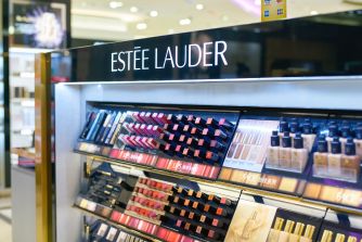 Estée Lauder cosmetics display featuring rows of makeup and skincare products in a retail setting.