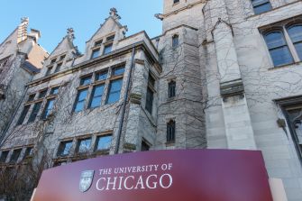 University of Chicago building facade with a maroon university sign in the foreground.
