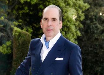 Julio Herrera Velutini poses outdoors in a navy suit and patterned tie.