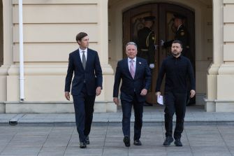 Jared Kushner, Steve Witkoff, and Ukrainian President Volodymyr Zelensky walk outside a building.