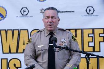 Former Los Angeles County Sheriff Alex Villanueva speaks at a podium in uniform during a law enforcement event.