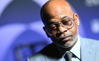 Damon Dash wearing glasses and a gray suit at a public event.
