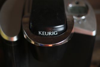Close-up of a Keurig coffee machine bearing the brand’s logo.