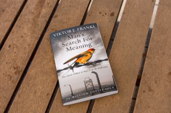 Viktor E. Frankl’s book “Man’s Search for Meaning” rests on a wooden slatted surface.