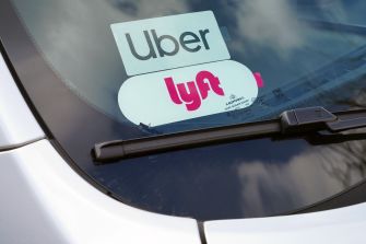 A close-up of an Uber and Lyft sticker displayed on a car windshield, highlighting the ride-share services.