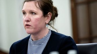 A woman speaking during a meeting, discussing issues related to consumer protection and the recent Supreme Court ruling affecting the FTC's powers.