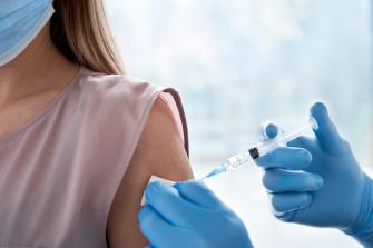 A close-up of a person receiving a vaccination in a clinical setting.