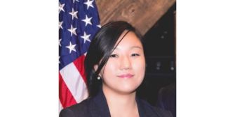 Portrait of Eun Young Choi, the newly appointed director of the National Cryptocurrency Enforcement Team, with the United States flag in the background.