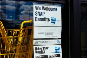 A sign on a store window indicating that it accepts SNAP benefits, part of the Supplemental Nutrition Assistance Program.