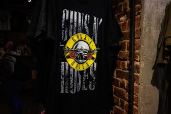 Guns N' Roses logo displayed on a black t-shirt hanging in a store.
