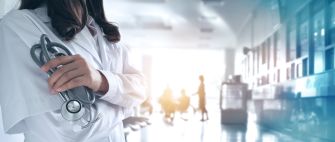 A healthcare professional holding a stethoscope in a hospital setting.
