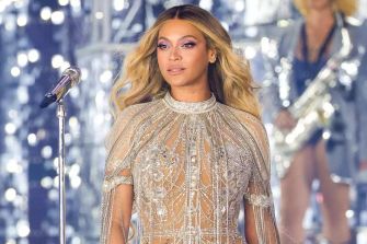 Beyoncé performing on stage in a shimmering outfit during a live concert.