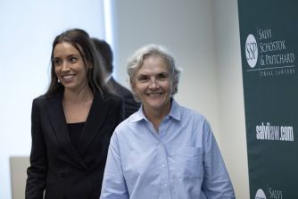 A smiling cancer survivor walks alongside her attorney after a jury awarded her $363 million in a lawsuit against a medical sterilization company.