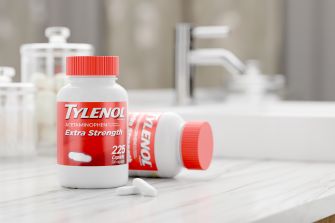 A bottle of Tylenol Extra Strength caplets on a bathroom countertop.