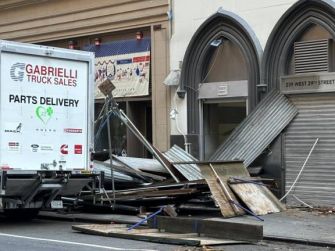 A collapsed scaffolding structure with debris scattered on the sidewalk, alongside a truck at the scene of the incident in Manhattan.