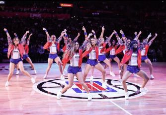 A group of Los Angeles Clippers dancers performing at a basketball game on the court.