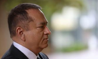 Close-up profile of Ramesh ‘Sunny’ Balwani, former Theranos executive, outdoors in a suit.