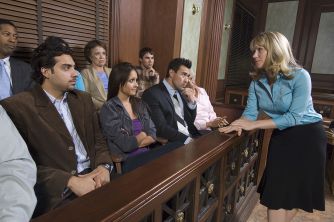 A diverse jury seated in a courtroom, listening to an attorney during a trial.