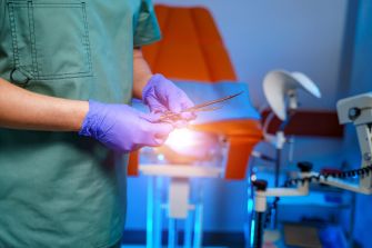 A medical professional holding surgical instruments in a healthcare setting.