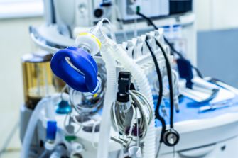 Medical equipment including oxygen tubes and a cauterizing device in a surgical setting.