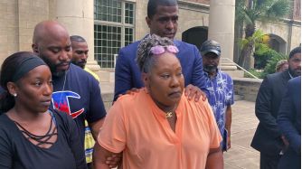 Family members of a woman who was fatally shot during a police search warrant gather outside a courthouse, expressing their grief and calls for justice.