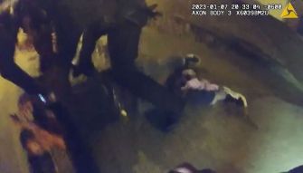 Body camera footage shows police officers restraining an unarmed man on the ground during a violent encounter.