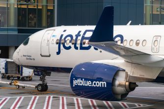 JetBlue airplane on the tarmac with jetblue.com visible on the engine.