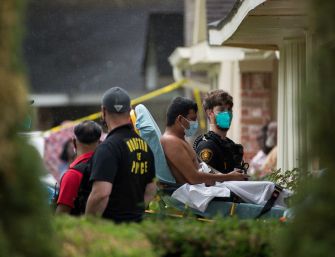Authorities assist an individual during a human smuggling investigation in Houston, where multiple migrants were found in a residential home.