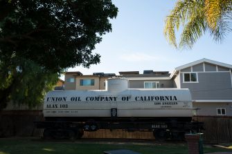 A vintage rail tank car labeled "Union Oil Company of California" located near residential buildings.