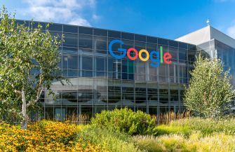 Google's headquarters building with colorful logo and surrounding landscaping.