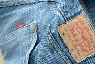 Close-up of blue denim jeans showing the Levi's leather patch and a small red tab on the pocket.