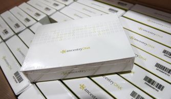 Ancestry.com DNA test kits stacked in a warehouse.