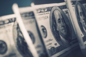 Close-up of American hundred dollar bills with a focus on Benjamin Franklin's portrait.