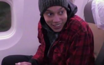 Brittney Griner smiling while seated on a plane after her release from detention in Russia.