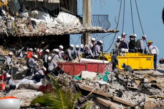 Rescue workers search through the rubble of the collapsed Champlain Towers South in Surfside, Florida, as recovery efforts continue.