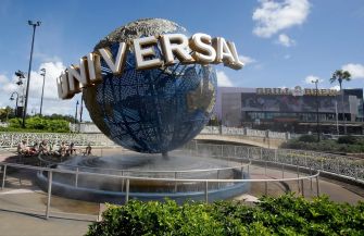 Universal Orlando globe entrance with restaurants in the background.