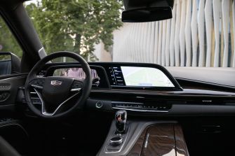 Interior of a GM vehicle featuring a steering wheel and a large touchscreen navigation display on the dashboard.