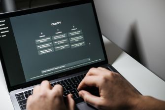 A person using a laptop displaying the ChatGPT interface.