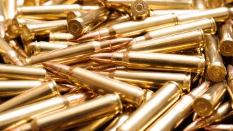 A close-up view of numerous golden bullet casings stacked together.