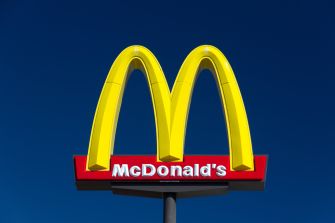 McDonald's logo with bright yellow arches against a blue sky.