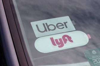Uber and Lyft stickers displayed in a car window.