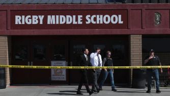 Exterior view of Rigby Middle School with authorities present and police tape surrounding the area after a shooting incident.