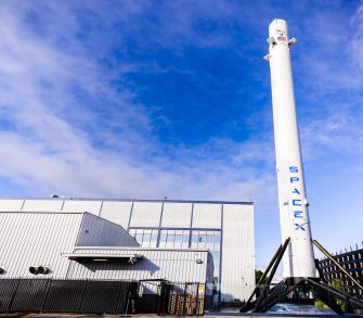 SpaceX facility with a Falcon 9 rocket in the foreground.