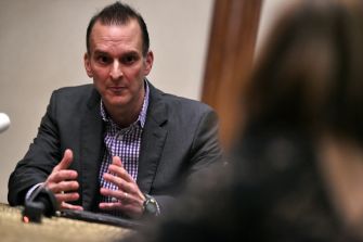 A man in a suit discusses topics related to anti-doping in sports during a meeting or conference.
