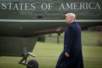 A person walking near a helicopter with the words "United States of America" visible.