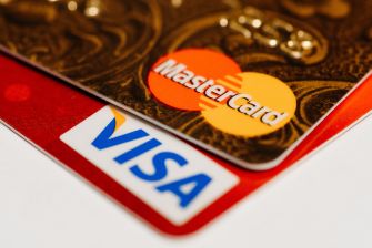 Close-up of Mastercard and Visa logos on overlapping credit cards.