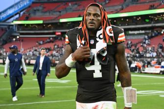Cleveland Browns quarterback Deshaun Watson walking off the field during a game, wearing a towel on his head.