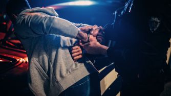 A police officer apprehending a suspect during a nighttime arrest.
