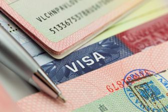Close-up of stacked passports and visa pages, with a visible United States visa stamp.